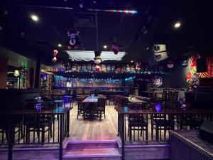 a restaurant with tables and chairs and a bar at Commercial Hotel in Edmonton