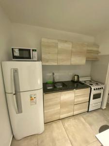 cocina con nevera blanca y microondas en FINCA NOVA Apartment 3 en Balcarce