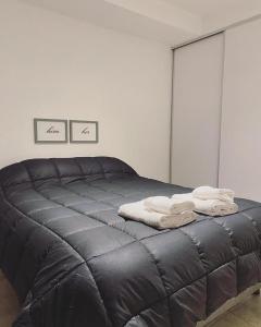 1 dormitorio con 1 cama con toallas en FINCA NOVA Apartment 3 en Balcarce