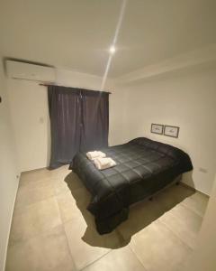 1 dormitorio con 1 cama negra en una habitación en FINCA NOVA Apartment 3 en Balcarce
