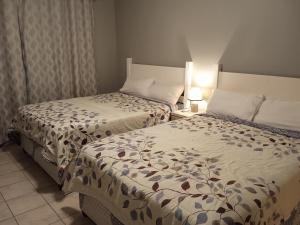 two beds in a hotel room withskirts at East-Coast Guesthouse: Serene, Private, Secure in Durban