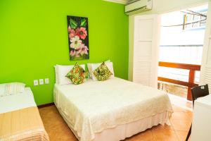a green bedroom with a bed in a room at Pousada Michele in Morro de São Paulo