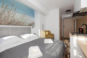 1 dormitorio con 1 cama y cocina con ventana en Willa Grand, en Rewal