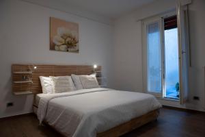 Un dormitorio blanco con una cama grande y una ventana en SunGarda Apartment, en Monzambano