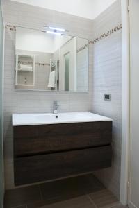 baño con lavabo grande y espejo en SunGarda Apartment, en Monzambano