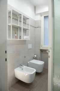 een witte badkamer met een wastafel en een toilet bij SunGarda Apartment in Monzambano