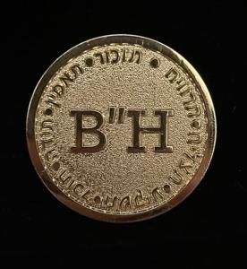 Une médaille d'argent avec le mot bitt sur elle dans l'établissement בקתה בכרם BH, à Nevatim
