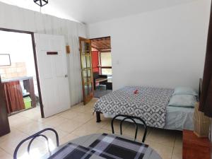 Habitación con cama, mesa y sillas. en Villasjungle 1 en Sámara