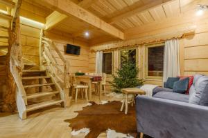a living room with a staircase in a log cabin at Domek Na Przełęczy wood house & mountain view in Murzasichle
