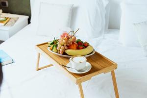 a plate of fruit and a cup of coffee on a table at Tuo Hotel in Polignano a Mare