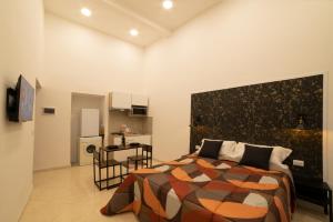 a bedroom with a large bed and a kitchen at Olina residence in Naples