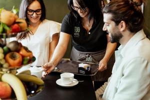 a group of people standing around a table with a tray of food at Tuo Hotel in Polignano a Mare