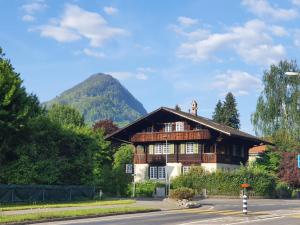 a wooden house with a mountain in the background at New renovated flat in protected chalet in Interlaken