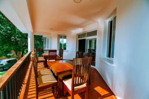 a porch with a wooden table and chairs at Dafina Residence in Dar es Salaam