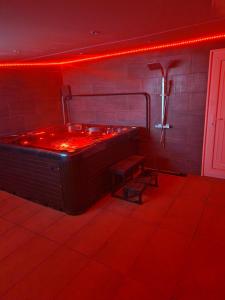 a red room with a tub with a bench in it at Short Stopzzz & Indoor Hot Tub in Manchester