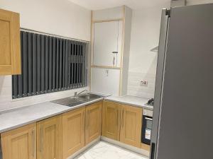 a kitchen with wooden cabinets and a sink at Short Stopzzz & Indoor Hot Tub in Manchester