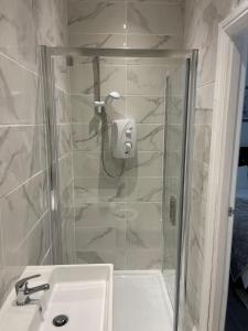 uma casa de banho com um chuveiro e um lavatório. em Short Stopzzz & Indoor Hot Tub em Manchester