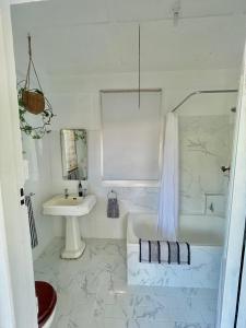 a white bathroom with a tub and a sink at Avalon II in Innisfail