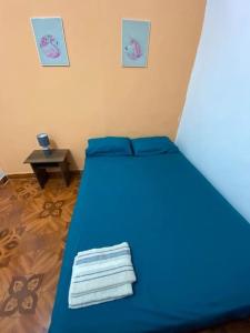 Cama azul en habitación con mesa en Dpto En GARZOTA a 5 Mnts del Aeropuerto, en Guayaquil