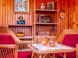 a room with wicker chairs and a table with a microwave at Holiday house Rukavina in Donje Pazarište