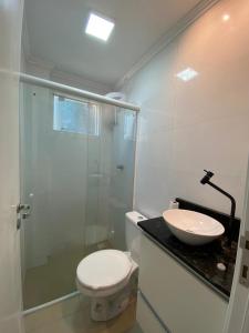 y baño con aseo, lavabo y ducha. en Casa tranquila 500 metros da praia do campeche, en Florianópolis