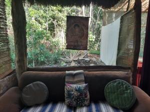 a couch sitting in a room with a window at Toto Aiko in Tulum
