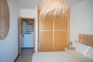 a bedroom with a bed with a wooden door and a staircase at Cozy 1 Bedroom Apartment with Sea View in Cotillo +23 photos