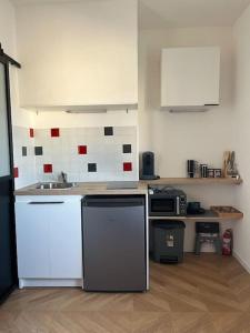 a kitchen with white counters and appliances in a room at Studio - Cosy Kaza in Angers