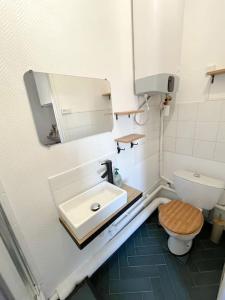 a bathroom with a toilet and a sink and a mirror at Studio - Cosy Kaza in Angers