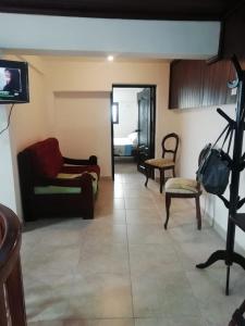 sala de estar con sofá y TV en Departamento vacacional, en Guayaquil