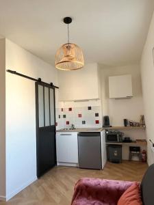 a room with a kitchen with a refrigerator and a table at Studio - Cosy Kaza in Angers