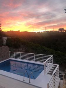 a swimming pool on top of a house with a sunset at Villa del Sol in Málaga