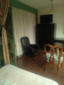 - une chambre avec une chaise noire et une chaise dans l'établissement Alcoba en Polanco (solo hombres), à Mexico