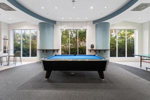 a pool table in a room with windows at Hollywood Beachfront Condo, Steps to Ocean, Pool & Game Room in Hollywood