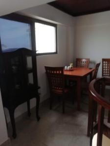 comedor con mesa, sillas y ventana en Departamento vacacional, en Guayaquil