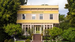 ein altes gelbes Haus mit grüner Tür in der Unterkunft Garden Street Inn Downtown San Luis Obispo, A Kirkwood Collection Hotel in San Luis Obispo