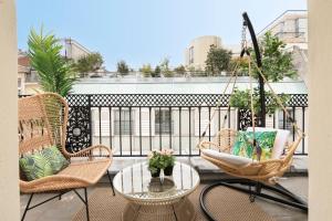 d'un balcon avec des chaises, une table et une balançoire. dans l'établissement 123paris city, à Paris 48 autres photos