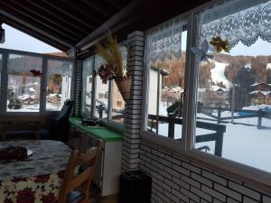una habitación con ventanas y una mesa con vistas a la nieve en Chalet Heidi, en Serrada