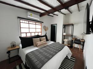 a bedroom with a bed and a television in it at Casa Medallo Hotel Boutique in Medellín