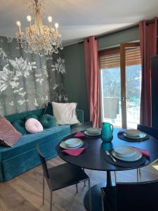 ein Wohnzimmer mit einem blauen Sofa und einem Tisch in der Unterkunft La Casetta di Bice al Villair di Morgex in Morgex