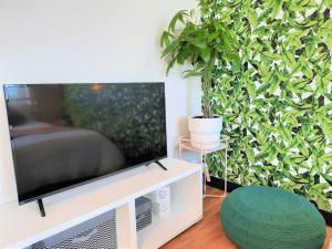 a living room with a tv and a potted plant at Hip Studio w/City Views Minutes to DT in Calgary