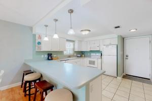 a kitchen with white cabinets and a blue counter top at El Matador 119 in Fort Walton Beach