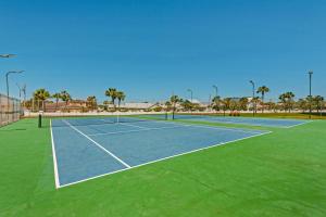 a tennis court with palm trees in the background at El Matador 119 in Fort Walton Beach