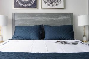 a bed with blue and white sheets and two lamps at 75-1D New 1BR prime UES W D the unit Best Value in New York