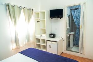 1 dormitorio con cama, TV y ducha en Pousada Michele en Morro de São Paulo
