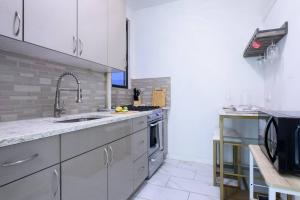 a white kitchen with a sink and a stove at 428-2W Newly Furnished Prime Location 2BR Sleeps 5 in New York