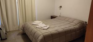 1 dormitorio con 1 cama con 2 toallas en Complejo Reliqua Dunamar Claromeco en Balneario Claromecó