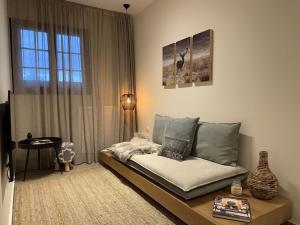 een woonkamer met een bed en een raam bij Ski Suites - Family Maisonette Kalavryta in Kalavrita