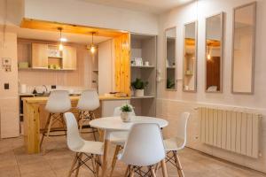 eine Küche mit einem Tisch und weißen Stühlen in der Unterkunft Departamento Céntrico Belgrano PBE in San Carlos de Bariloche