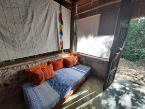 a bench with pillows in a room with a window at Toto Aiko in Tulum
